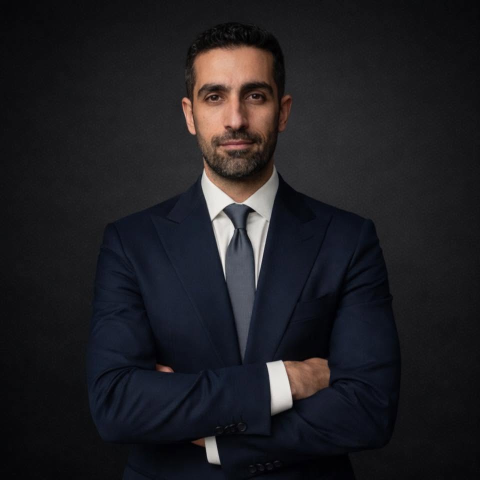 Dr. Emad Deen, specialist orthodontist, arms folded, in a navy suit